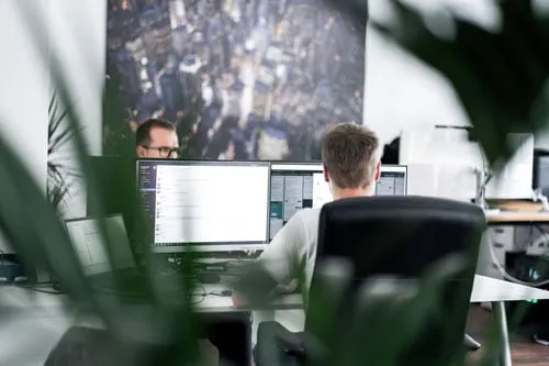 Seven Bytes Media Team bei der Arbeit an zwei Monitoren