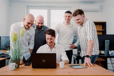 Authentisches Teamfoto: Mitarbeiter besprechen gemeinsam ein Projekt am Laptop
