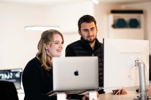 Seven Bytes Team bei der Zusammenarbeit am iMac